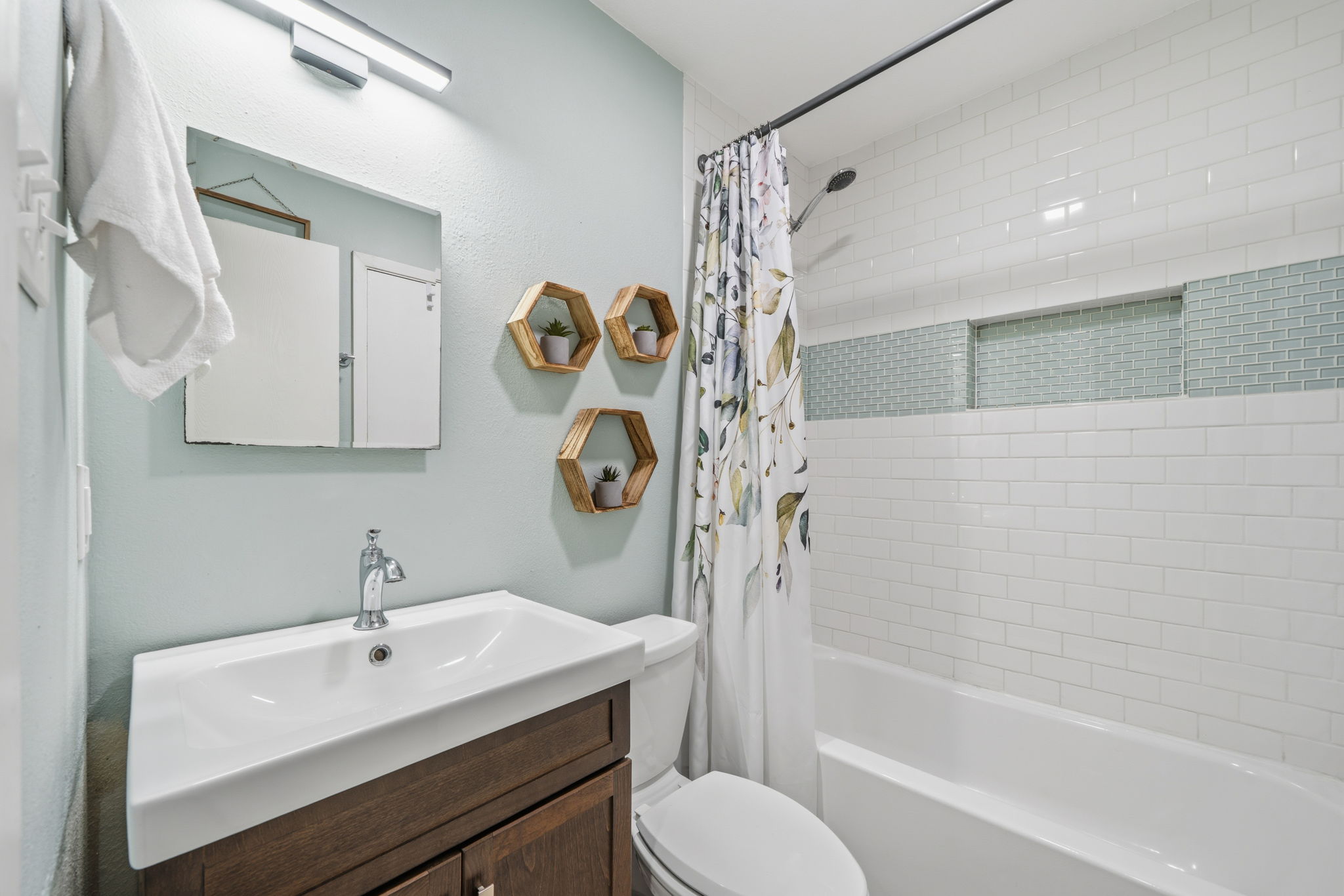 705 Dulwich Street Austin, TX 78748 - Photo 12 of 36 A well-appointed bath features a tiled tub and shower, alongside a chic vanity with modern fixtures.