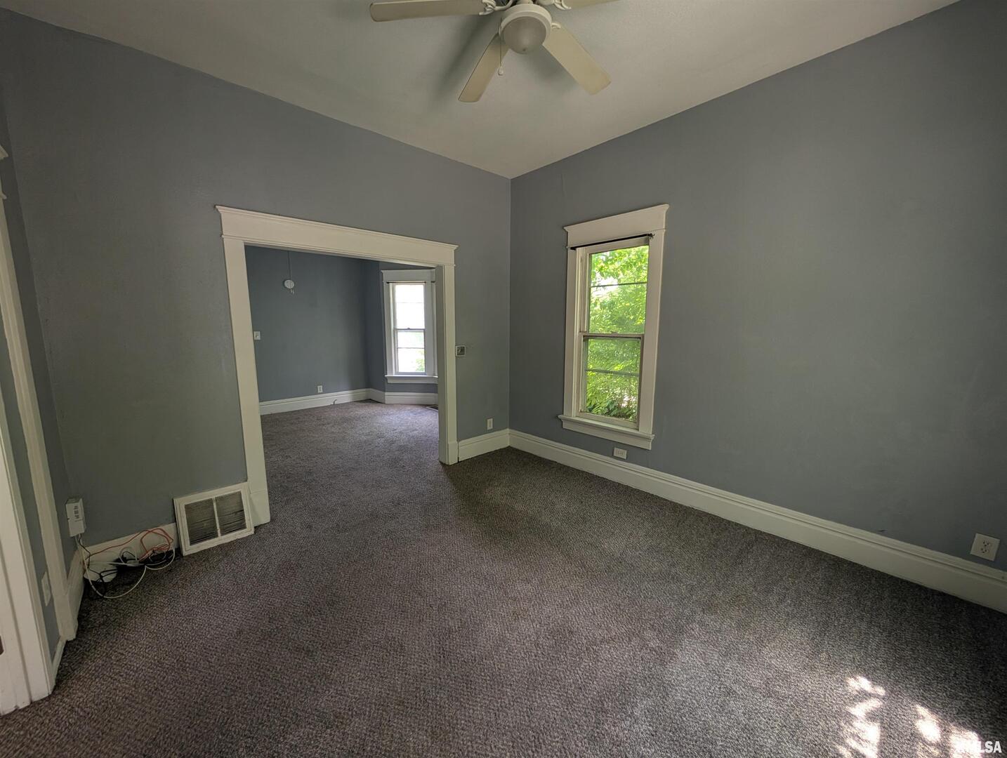 2833 8th Avenue Rock Island, IL 61201 - Photo 3 of 21 an empty room with a chandelier fan and windows