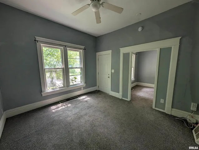 an empty room with windows and closet