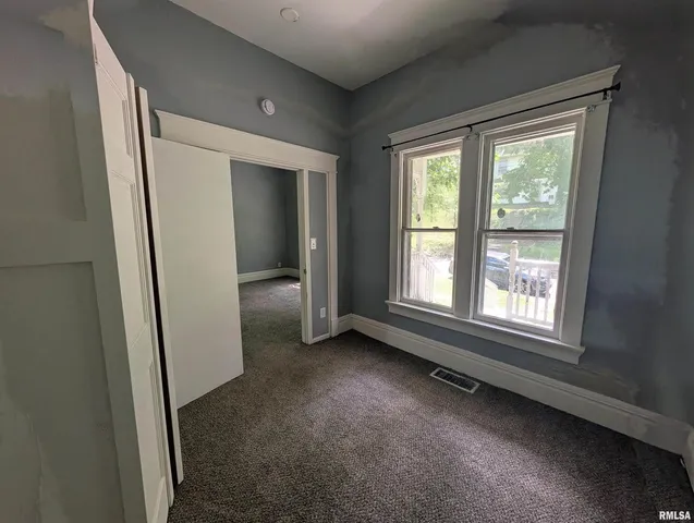 an empty room with windows and closet