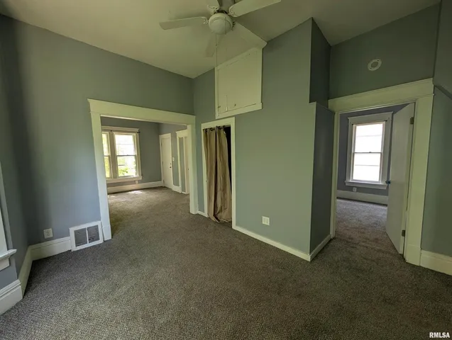 an empty room with wooden floor and entryway