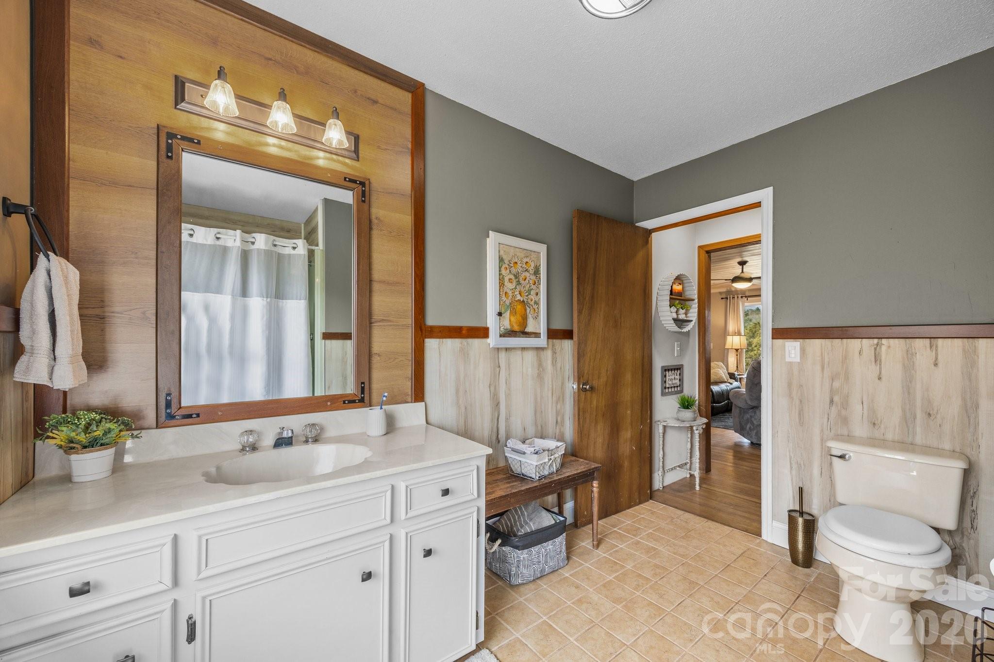 774 Belleview Road Franklin, NC 28734 - Photo 19 of 36 a spacious bathroom with a granite countertop sink and a mirror