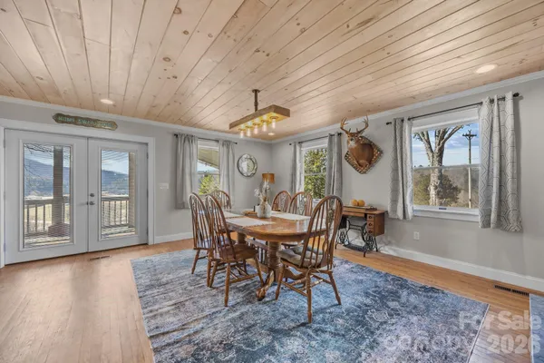 a dining room with wooden floor and a fireplace