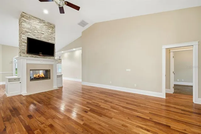 a kitchen with stainless steel appliances kitchen island granite countertop a stove top oven a sink a dining table and chairs with wooden floor