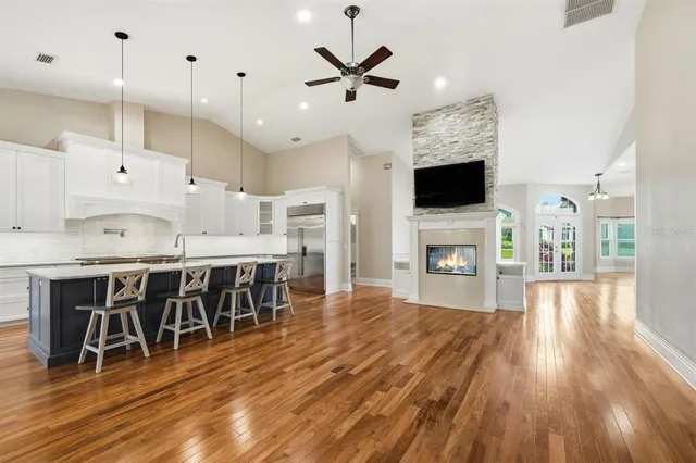 a kitchen with granite countertop a table chairs stainless steel appliances and cabinets