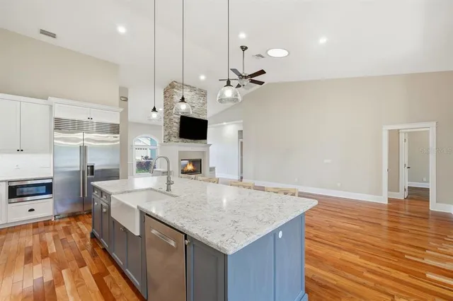 a kitchen with granite countertop a stove and a white cabinets