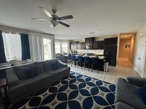 a living room with furniture a flat screen tv and a window