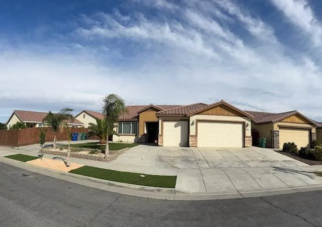 a view of house with yard and car parked