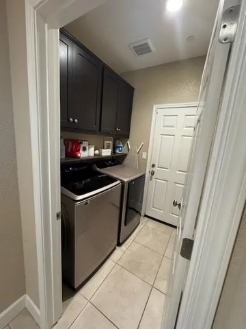 a utility room with cabinets washer and dryer