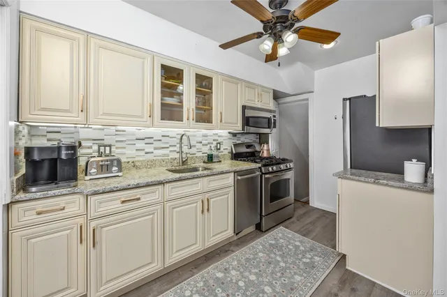a kitchen with stainless steel appliances granite countertop a stove a sink and a refrigerator