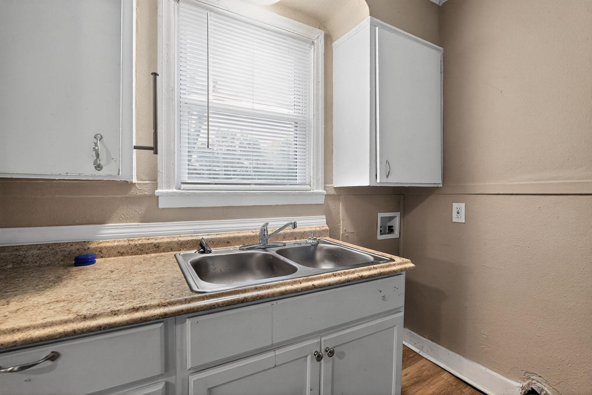 356 Hewlett Road Memphis, TN 38109 - Photo 10 of 30 Kitchen with a textured wall, white cabinets, light countertops, and wood finished floors
