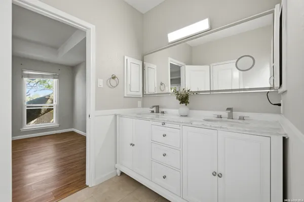a bathroom with double sink and a mirror