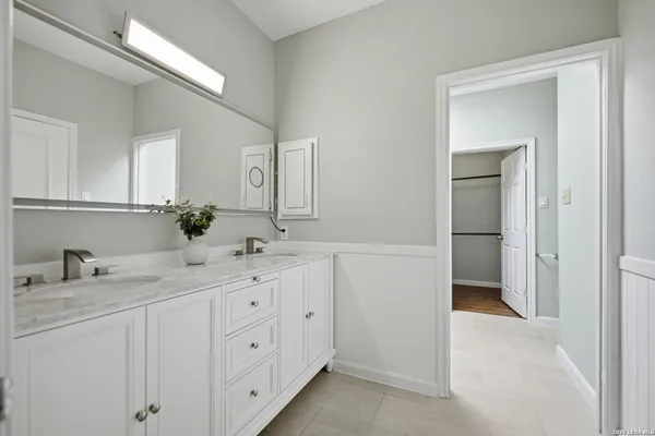 a bathroom with a double vanity sink and a mirror