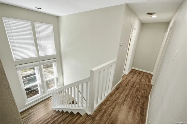 a view of a hallway with wooden floor and staircase