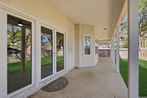 a view of a porch with a floor to ceiling window and garden