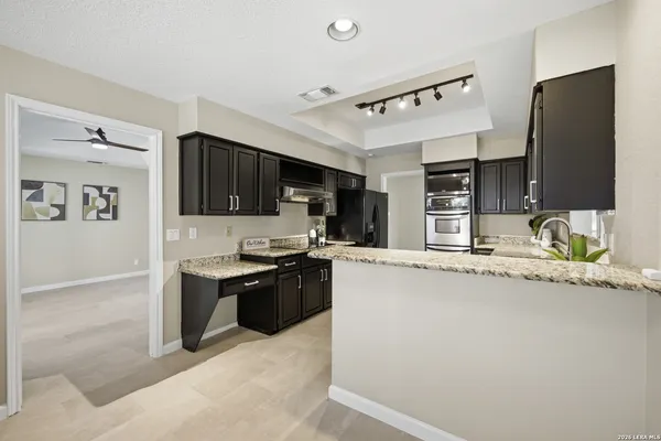 a kitchen with granite countertop a sink stove and refrigerator