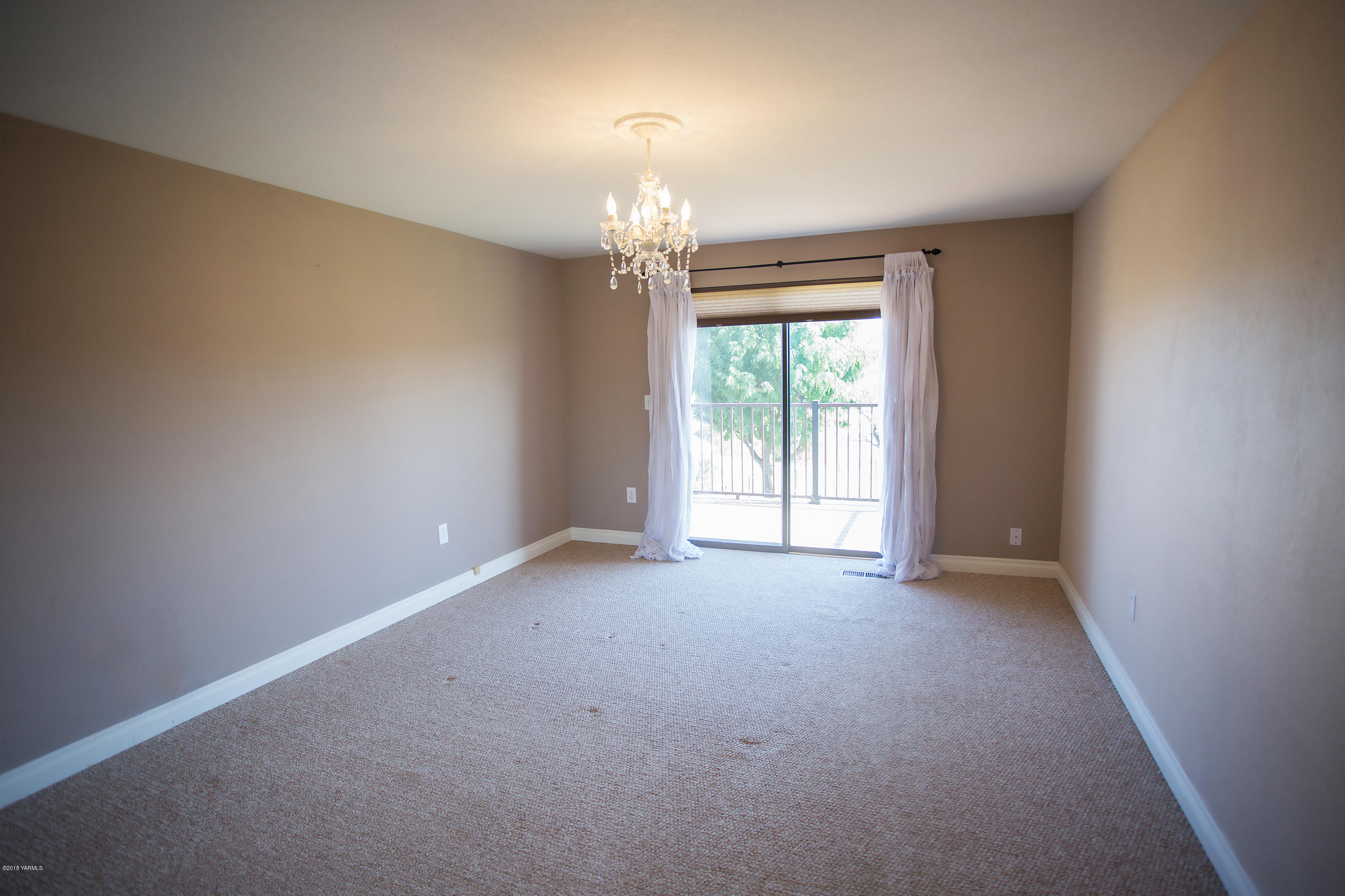 13077 Douglas Road Yakima, WA 98908 - Photo 14 of 35 an empty room with windows and chandelier