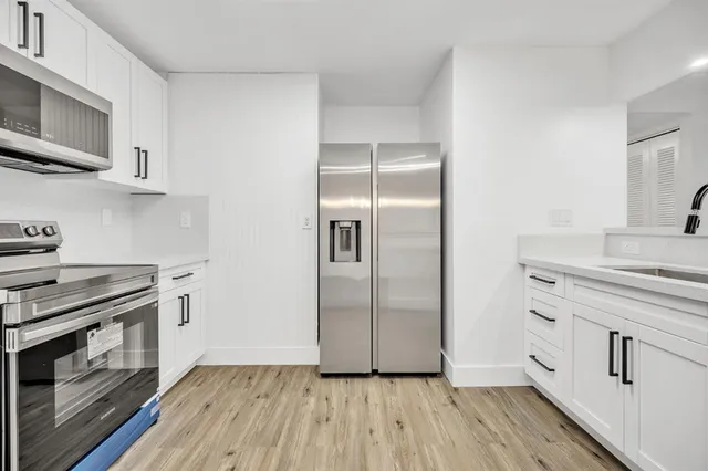 a view of a kitchen with wooden floor and a potted plant