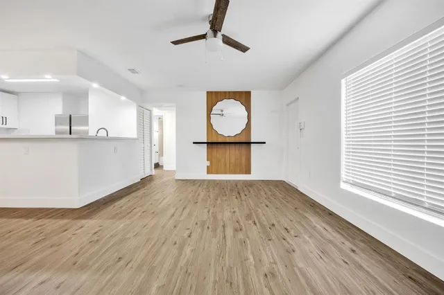 a view of a kitchen with wooden floor and a ceiling fan