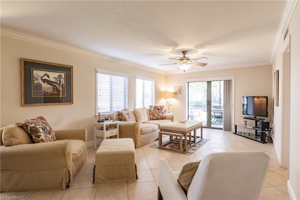 910 Vanderbilt Beach Road, Unit 311W Naples, FL 34108 - Photo 12 of 31 a living room with furniture ceiling fan and a window