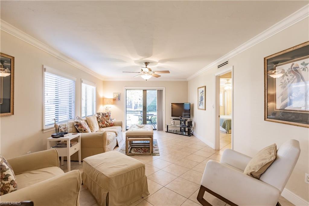 910 Vanderbilt Beach Road, Unit 311W Naples, FL 34108 - Photo 13 of 31 a living room with furniture and large windows