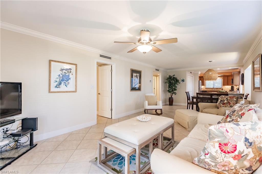 910 Vanderbilt Beach Road, Unit 311W Naples, FL 34108 - Photo 14 of 31 a living room with furniture a flat screen tv and kitchen view