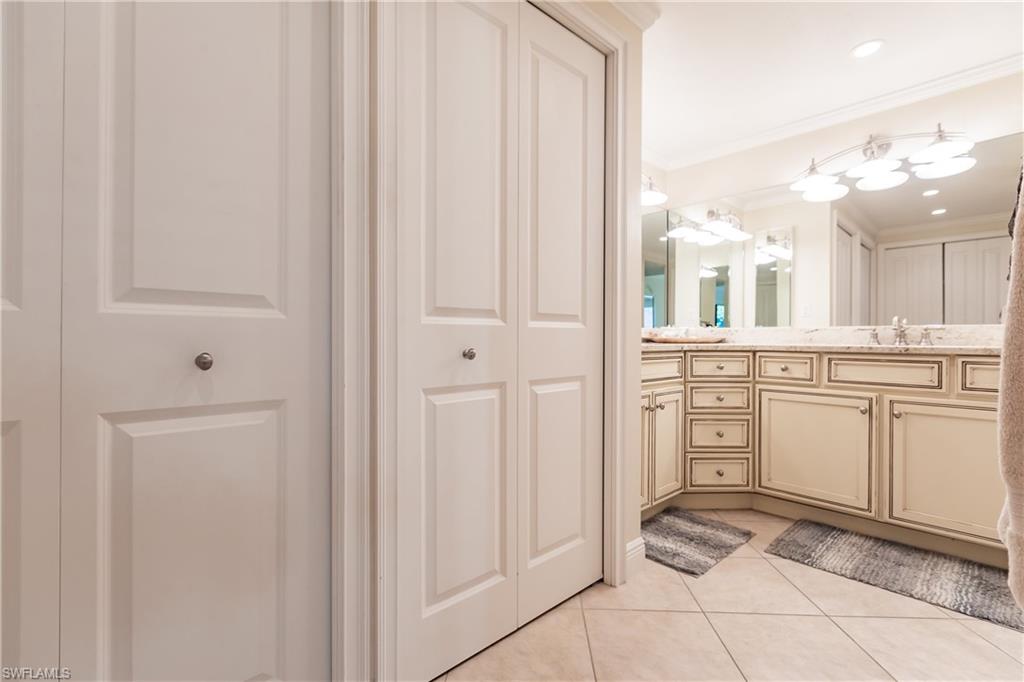 910 Vanderbilt Beach Road, Unit 311W Naples, FL 34108 - Photo 21 of 31 a bathroom with a sink a vanity and a mirror