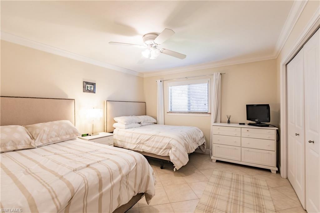 910 Vanderbilt Beach Road, Unit 311W Naples, FL 34108 - Photo 25 of 31 a bedroom with two beds and a flat screen tv