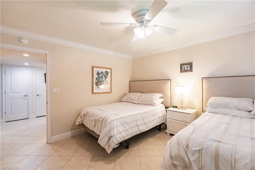 910 Vanderbilt Beach Road, Unit 311W Naples, FL 34108 - Photo 26 of 31 a bedroom with a bed and a chandelier