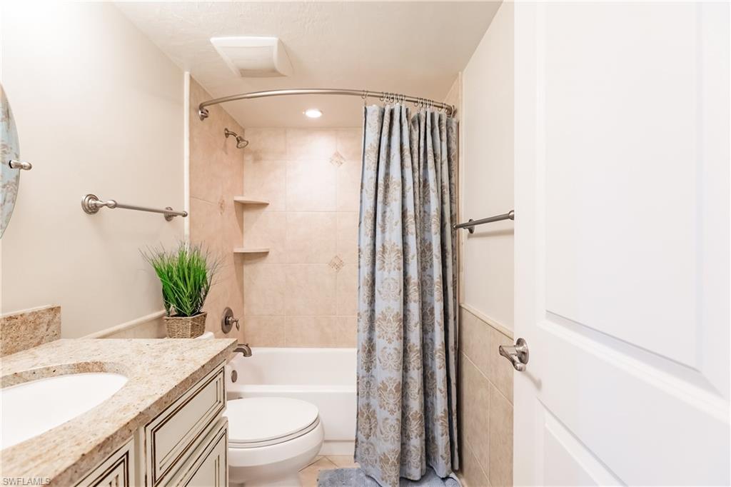 910 Vanderbilt Beach Road, Unit 311W Naples, FL 34108 - Photo 29 of 31 a bathroom with a granite countertop sink toilet and shower