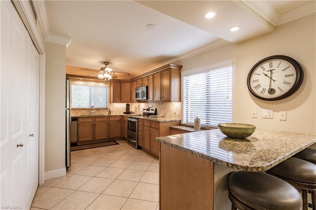 910 Vanderbilt Beach Road, Unit 311W Naples, FL 34108 - Photo 3 of 31 a kitchen with stainless steel appliances granite countertop a sink a stove and a refrigerator