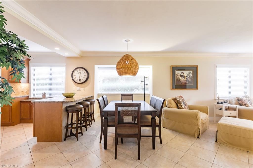 910 Vanderbilt Beach Road, Unit 311W Naples, FL 34108 - Photo 9 of 31 a dining room with furniture and a mirror