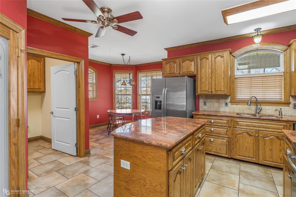 703 Airport Loop Homer, LA 71040 - Photo 7 of 32 a kitchen with stainless steel appliances granite countertop a sink and a refrigerator