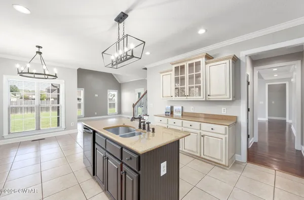 a kitchen with stainless steel appliances a sink a stove a refrigerator cabinets and a window