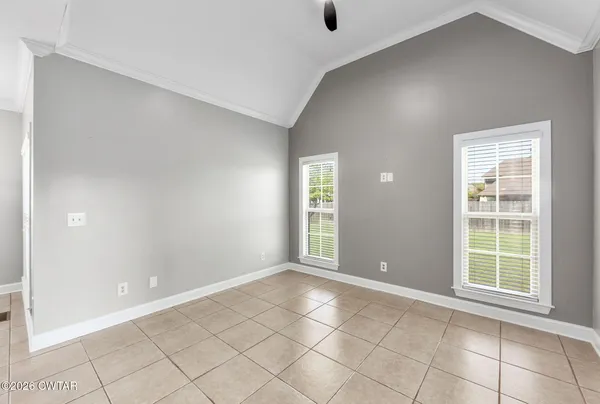 a view of an empty room with closet and a window