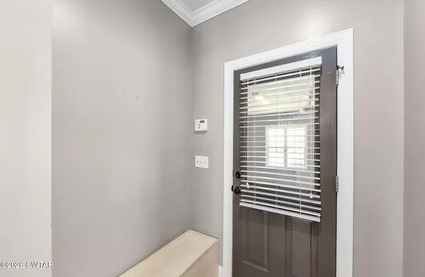 an empty room with ceiling fan and window