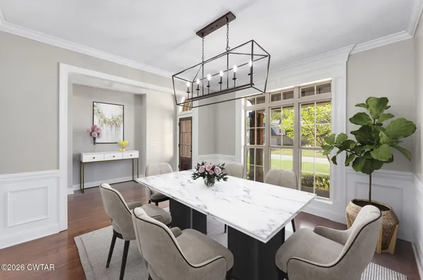 a dining room with furniture potted plants and wooden floor