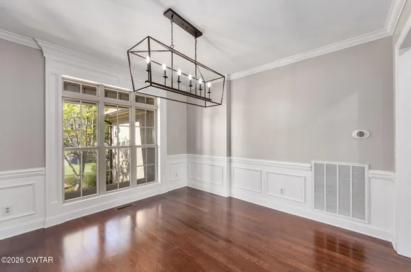 a view of empty room with wooden floor and windows