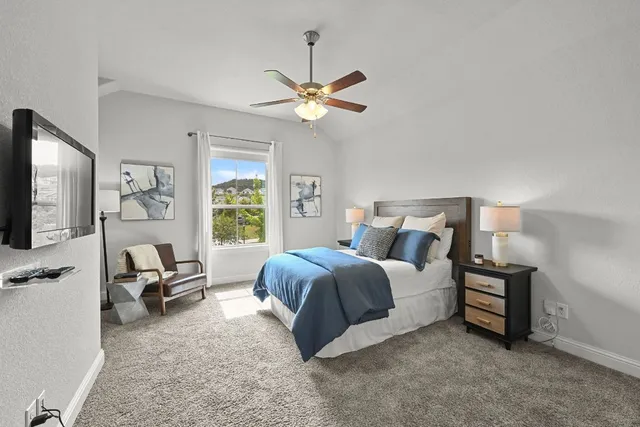 a spacious bedroom with a bed a couch and a chandelier