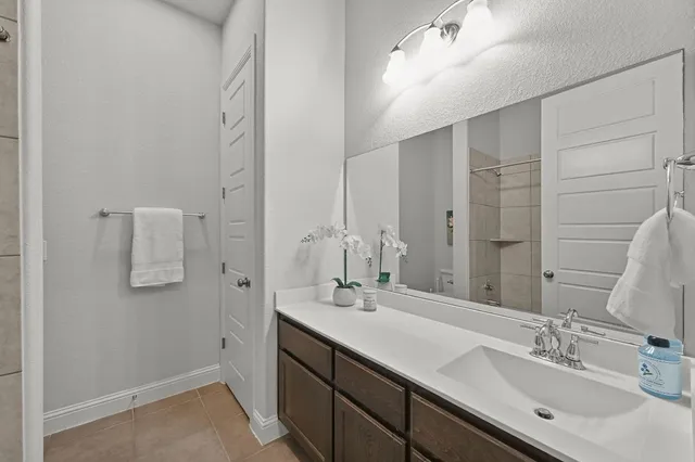 a bathroom with a double vanity sink a mirror and shower