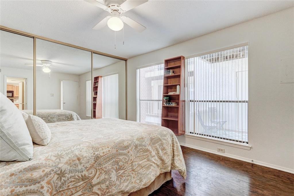 3115 Helms Street, Unit 204 Austin, TX 78705 - Photo 5 of 13 Hardwood flooring extends throughout this naturally illuminated bedroom with mirrored closet doors.