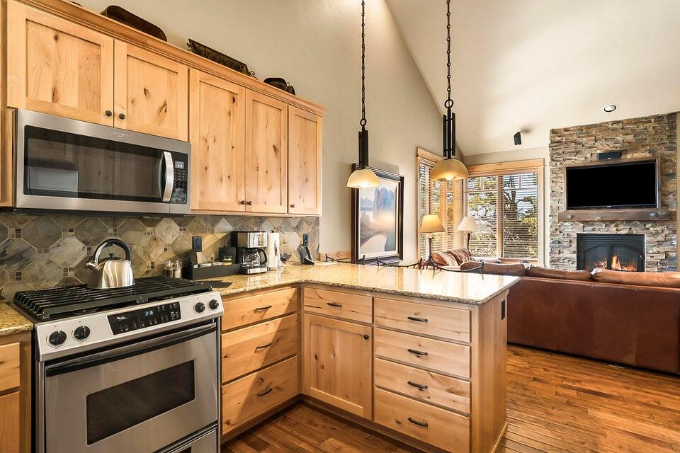 16845 South W Brasada Ranch Road, Unit 23 Powell Butte, OR 97753 - Photo 18 of 47 a kitchen with stainless steel appliances granite countertop a stove microwave and cabinets