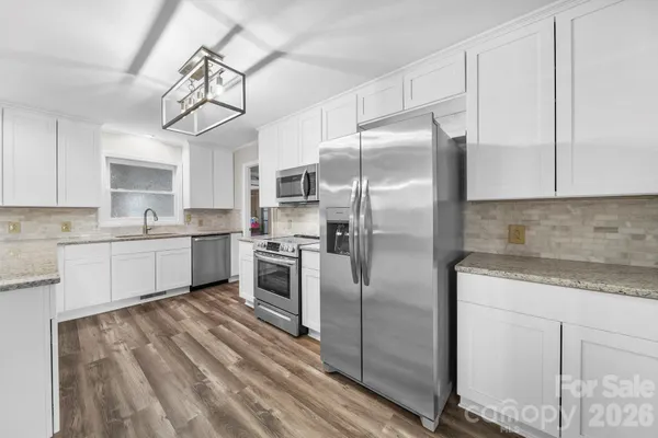 a kitchen with cabinets stainless steel appliances and a counter space