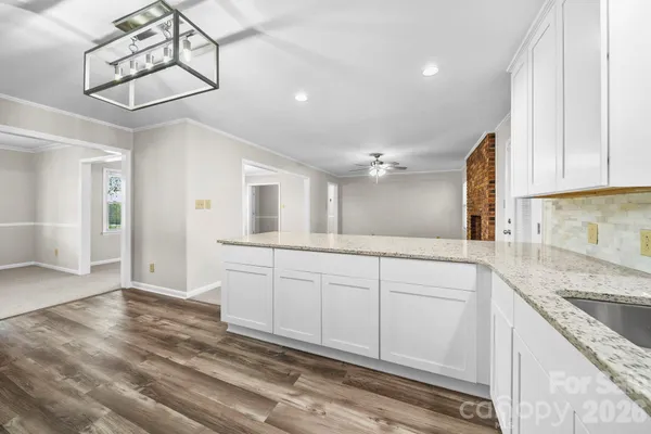a spacious bathroom with a granite countertop sink a mirror and shower