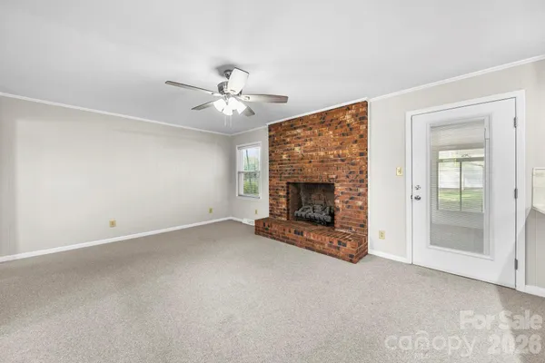 an empty room with fireplace and fan