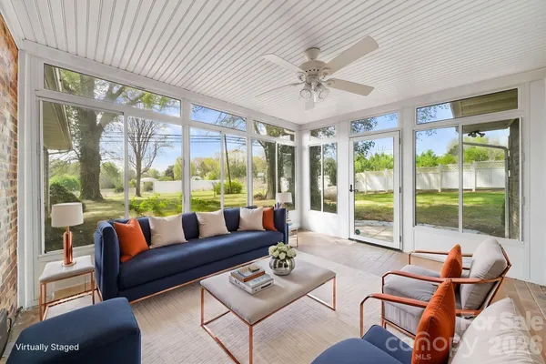 a living room with furniture and floor to ceiling windows