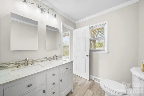 a bathroom with a granite countertop sink mirror vanity and toilet