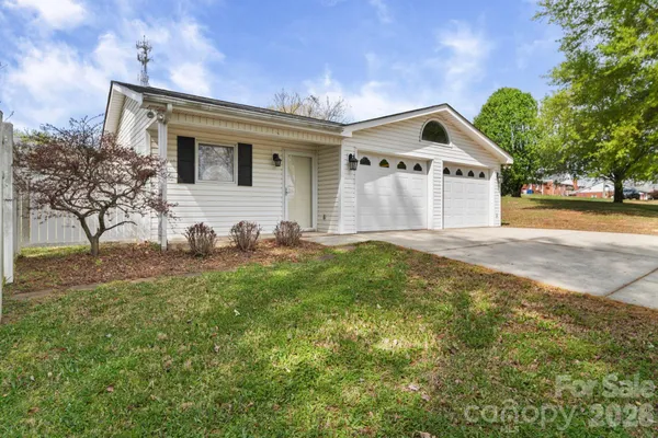 a view of house with yard and trees in the background
