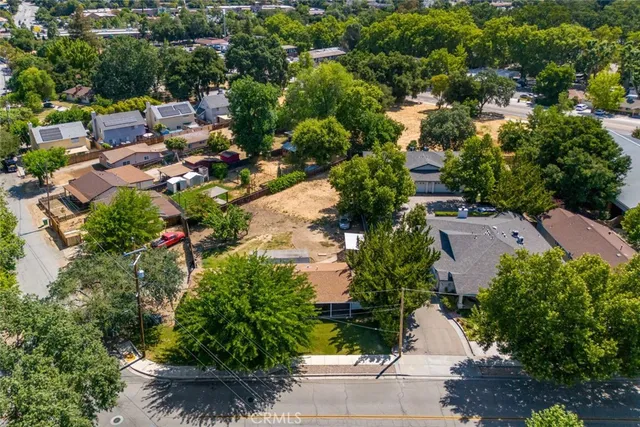 an aerial view of residential houses with outdoor space and trees all around