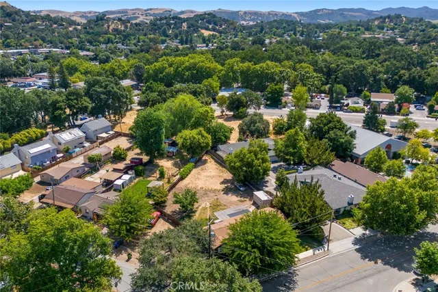 an aerial view of residential houses with outdoor space and trees